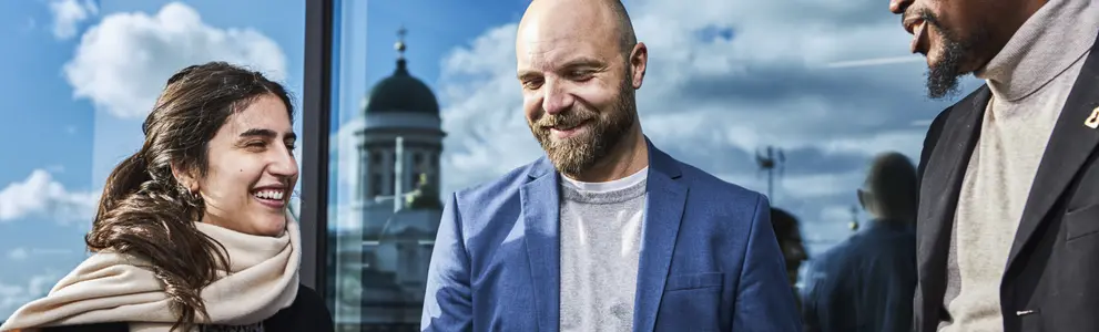 Kolme ihmistä keskustelee.