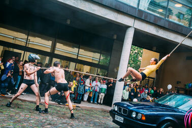 A person performing on a tightrope in front of a large audience.