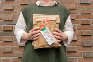 A person is holding wrapped books in their hands.