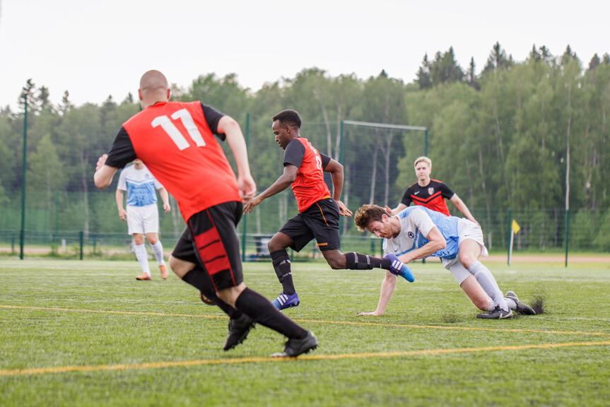 En fotbollsmatch pågår på utomhusplanen. 