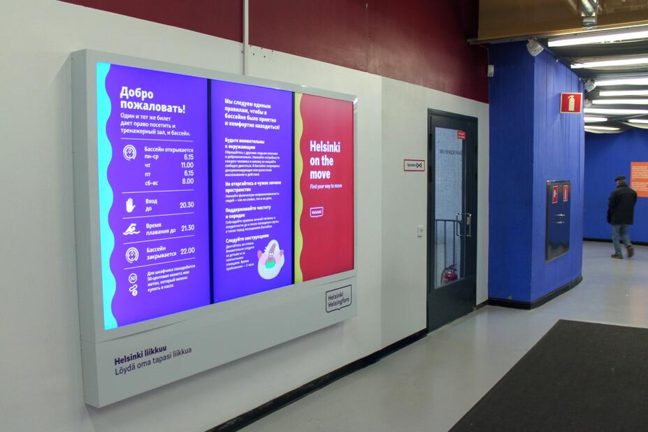 In the lobby, there is a large digital display with text in Russian and English.