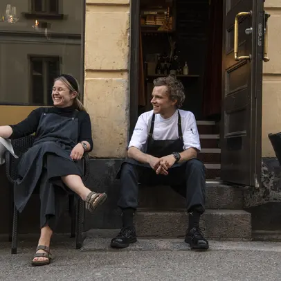 Two people in front of a restaurant having a break.