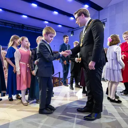 Poika kättelee pormestaria.
