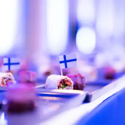 Tarjoiluja, joissa pieniä siniristilippuja.