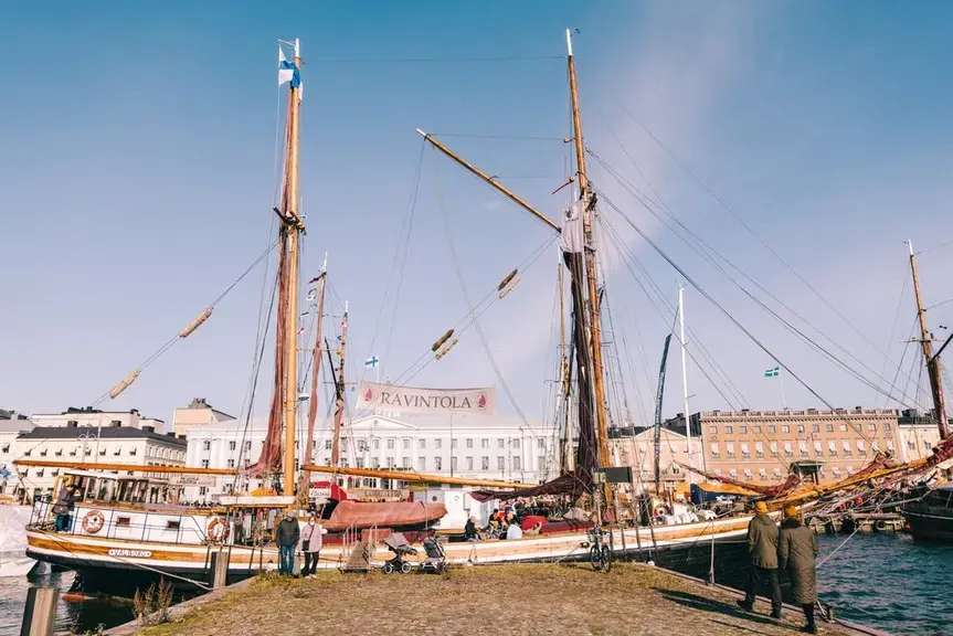 A sailing ship without sails at the end of a pier.