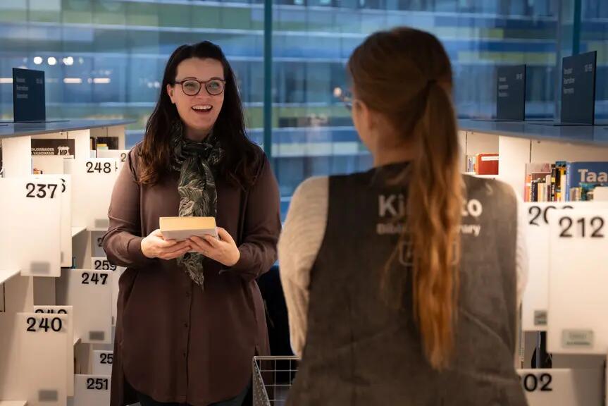Kahden naisen kohtaaminen Helsingin keskustakirjasto Oodissa.