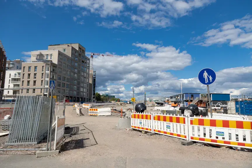 Työmaa-aita, jonka edessä jalankulun liikennemerkki.