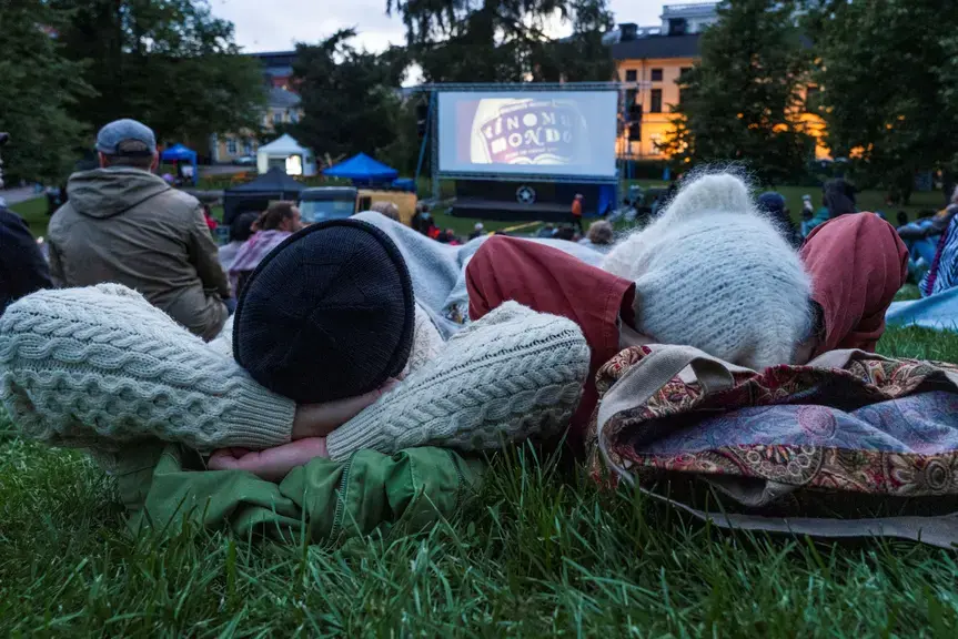 Two people are watching an outdoor movie.