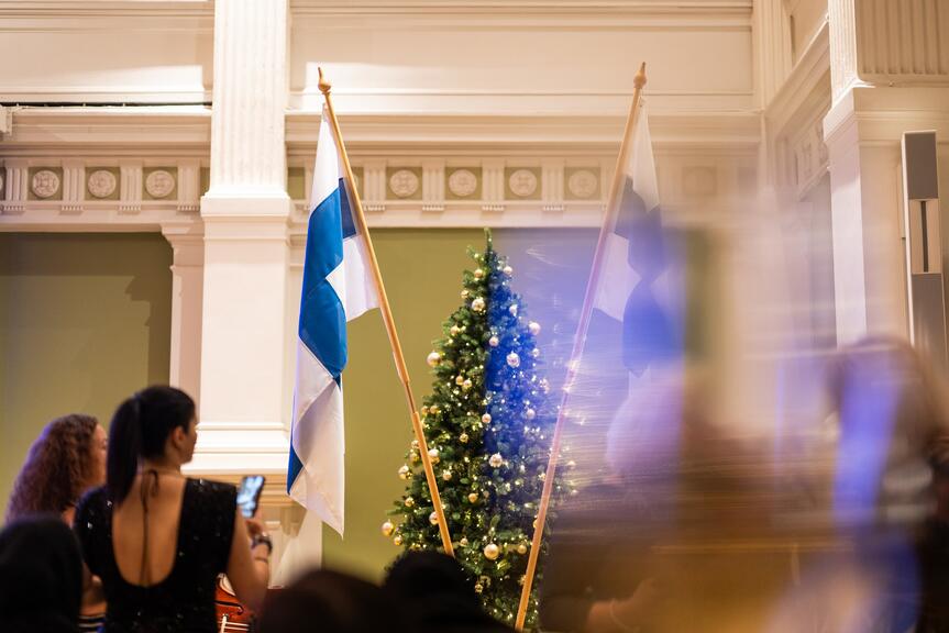 Suomen liput ja koristeltu joulukuusi kaupungintalon juhlasalissa.
