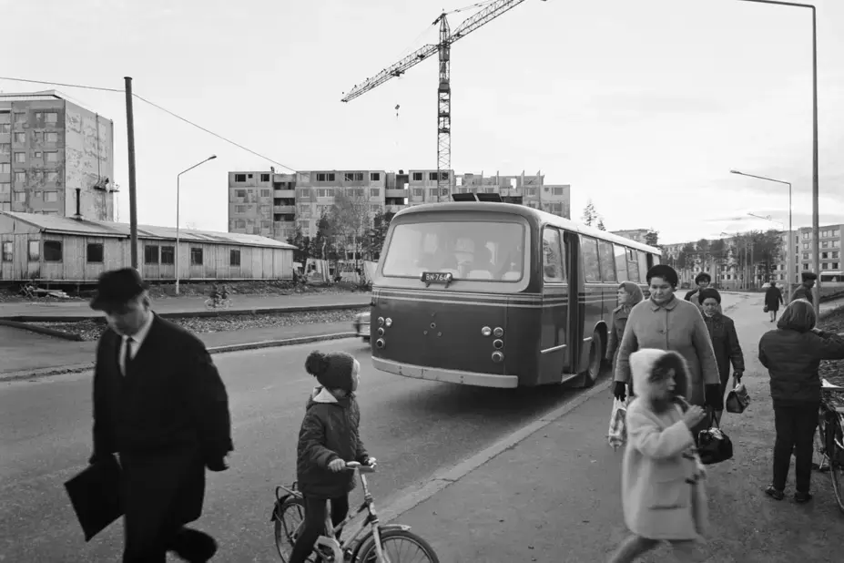 Människor vid en busshållplats i Kontula 1967. En byggarbetsplats syns i bakgrunden.