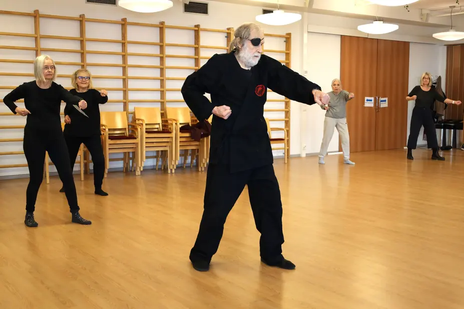 En karategrupp på servicecentret, där läraren och gruppdeltagarna utövar rätt teknik.
