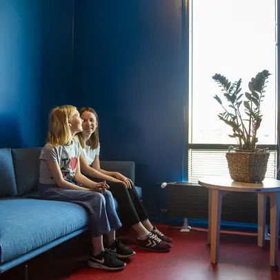 Two young people are sitting in Herttoniemi library.