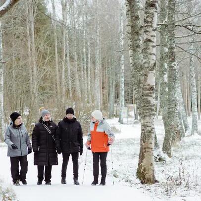 Fyra personer på promenad i ett vinterlandskap.
