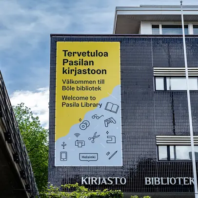 Pasilan kirjaston julkisivussa on Helsinki ilmeellä toteutettu  iso banderolli jossa tekstiä ja kuvitusikoneja 