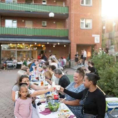 Leende människor som äter middag utomhus i Malmgård.