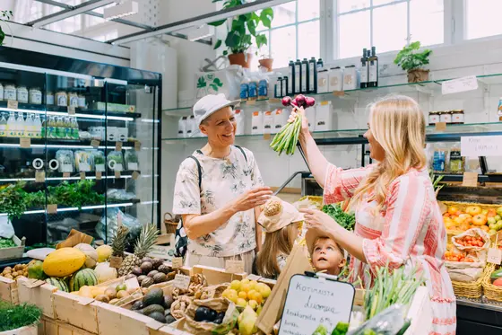 Två glada personer köper grönsaker i Hagnäs saluhall.