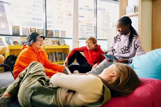 Young people smiling at each other in a library.
