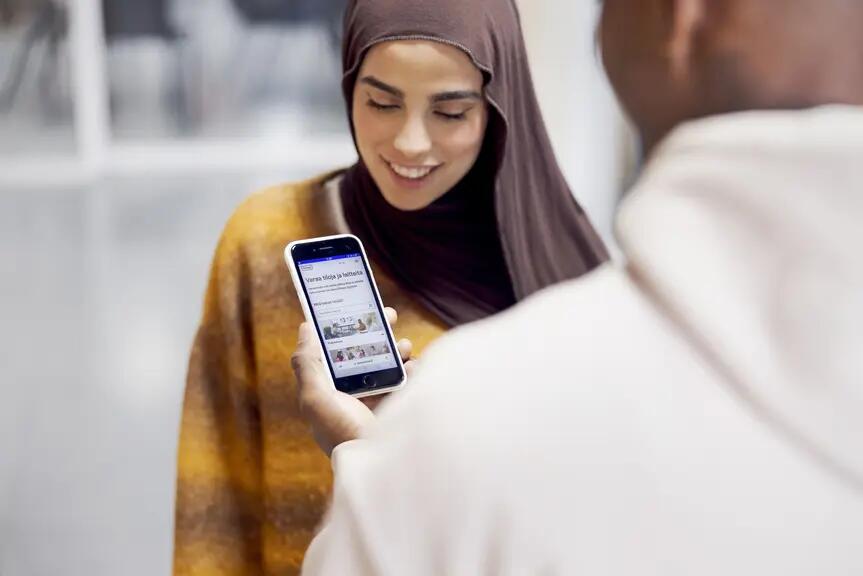 Kaksi opiskelijaa ovat tekemässä tilavarausta Varaamon mobiilisovelluksella.