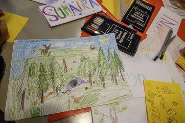 Lasten piirustuksia pöydällä.