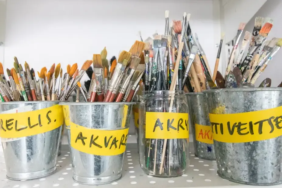 Kuvassa on metallipurkeissa erilaisia siveltimiä.