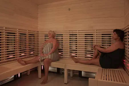 Two people are sitting in the infrared sauna at Yrjönkatu Swimming Hall.
