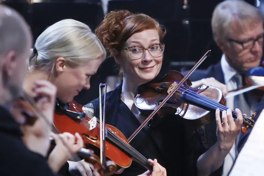 Violinists of the city orchestra playing the violin.