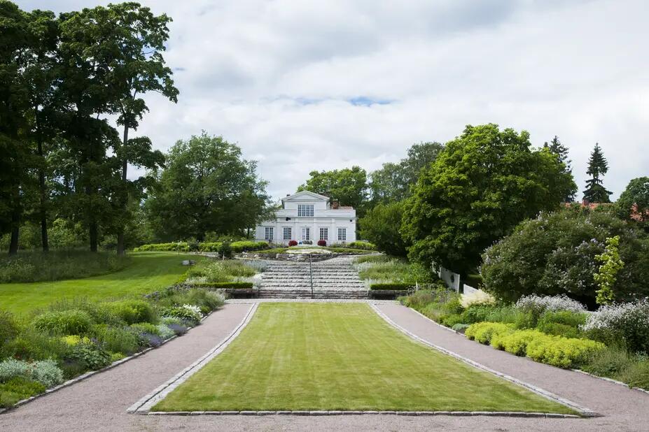 Perennplanteringar i parken vid Villa Anneberg och villan i bakgrunden.