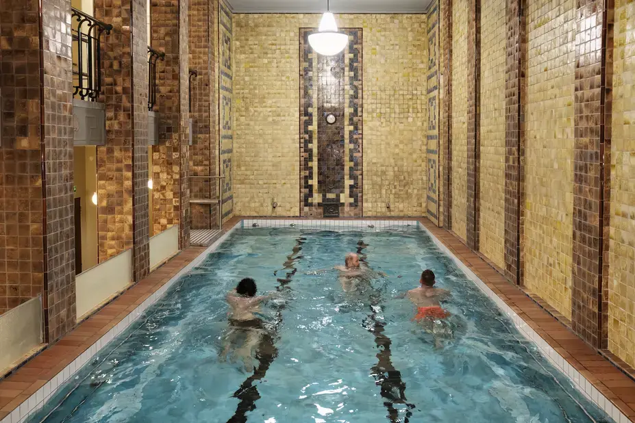Three people are swimming in a small pool.
