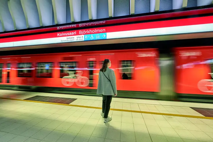 Woman waiting for incoming train in Koivusaari metro station.