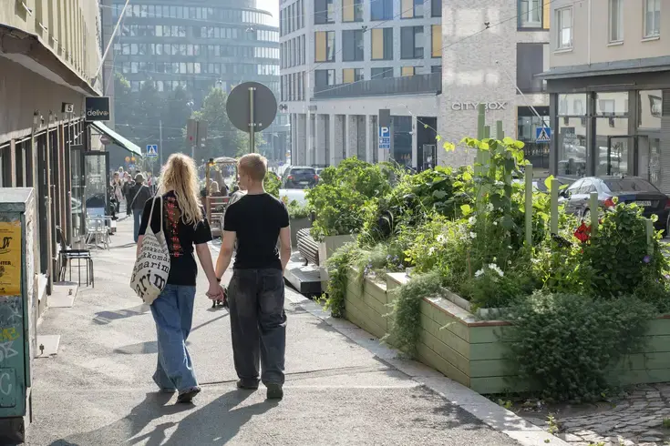 Kukkaistutuksia Porthaninkadulla, pariskunta kävelee käsi kädessä.