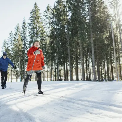 Valoisa tasainen latu ja hiihtäjiä.